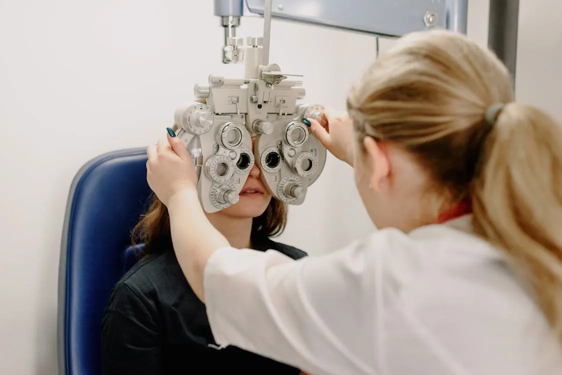 Senior man at a comprehensive eye examination, optometrist using a slit lamp to examine the retina and optic nerve